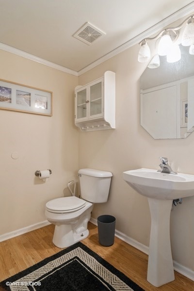 bathroom featuring sink, crown molding, hardwood / wood-style flooring, and toilet