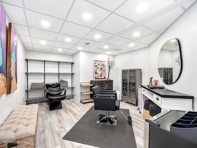 office area with a drop ceiling and light wood-type flooring