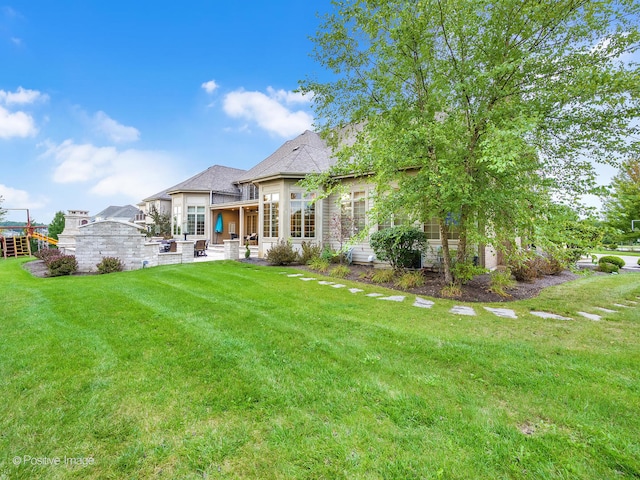 back of property featuring a patio area and a yard