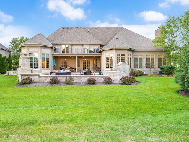 back of property with a balcony, outdoor lounge area, a yard, and a patio area