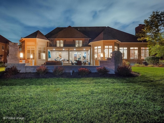 back of house with a patio, a lawn, and a balcony