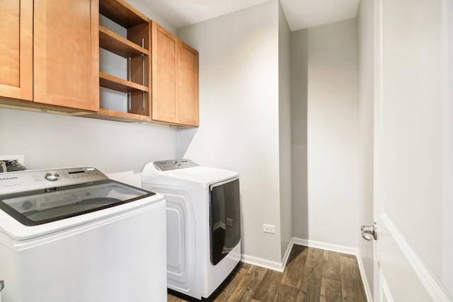 laundry area featuring dark wood-type flooring, separate washer and dryer, and cabinets