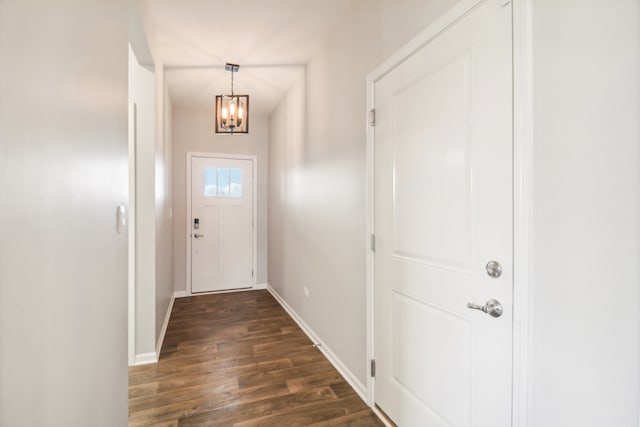 doorway to outside with a notable chandelier and dark wood-type flooring