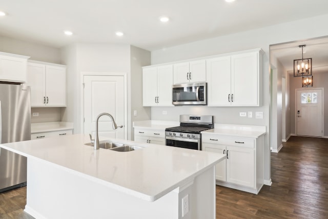 kitchen featuring a kitchen island with sink, dark hardwood / wood-style floors, stainless steel appliances, sink, and white cabinets