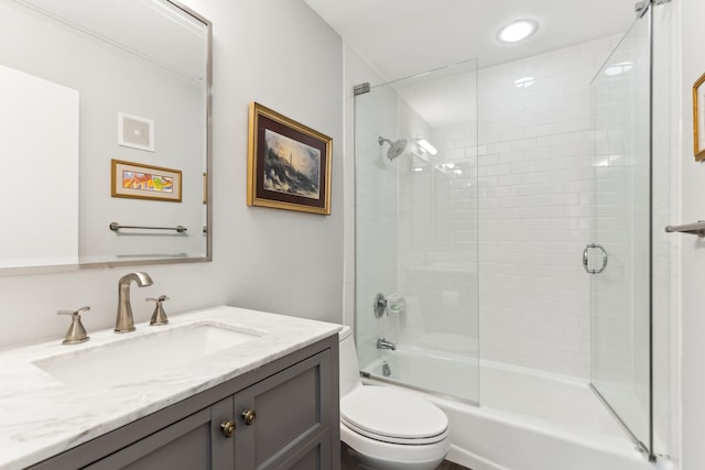 full bathroom featuring vanity, enclosed tub / shower combo, and toilet