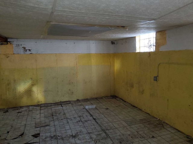 basement featuring a paneled ceiling