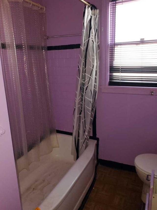 bathroom with shower / bath combo with shower curtain and toilet