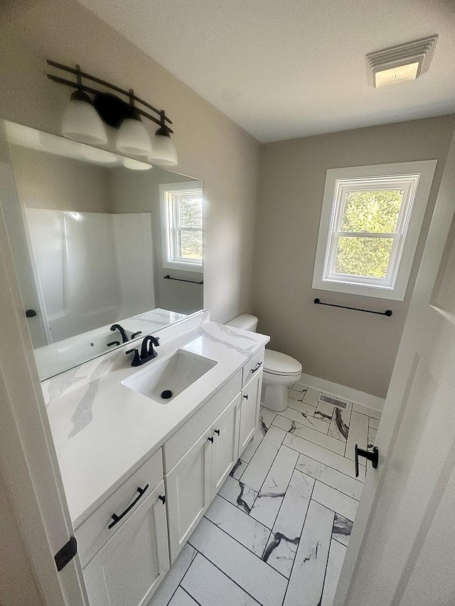 bathroom with vanity, toilet, and a textured ceiling