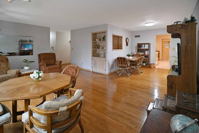 dining room with light hardwood / wood-style flooring and built in features