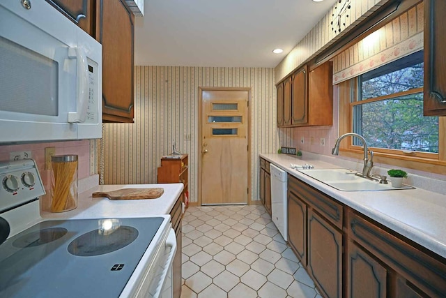 kitchen featuring sink, light tile patterned floors, and white appliances