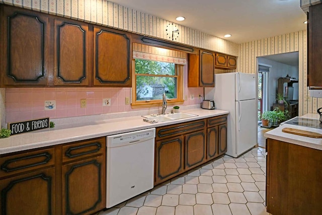 kitchen with backsplash, sink, and white appliances