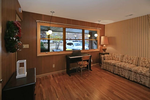 living room featuring dark hardwood / wood-style flooring and wooden walls