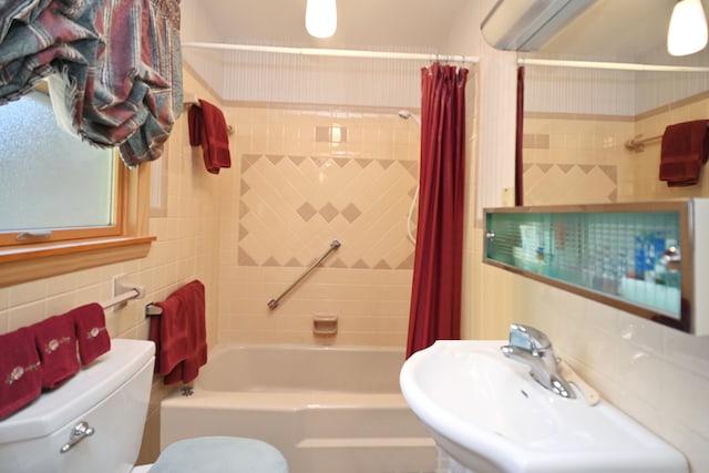 full bathroom featuring sink, decorative backsplash, toilet, tile walls, and shower / tub combo