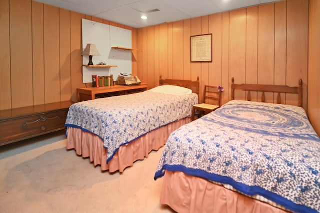 carpeted bedroom featuring wooden walls