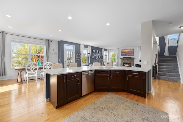 kitchen with sink, light hardwood / wood-style flooring, a healthy amount of sunlight, and dishwasher