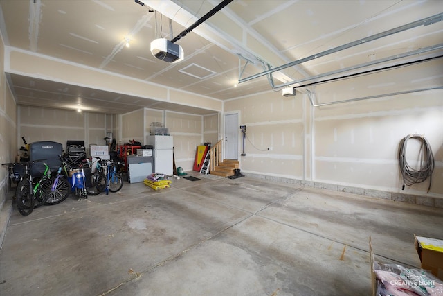 garage with a garage door opener and white refrigerator