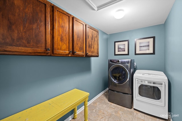 laundry area with cabinets and washer and clothes dryer