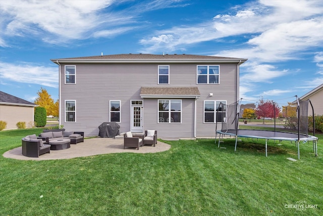 back of property with outdoor lounge area, a yard, a trampoline, and a patio area