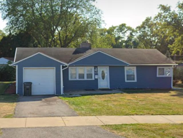 single story home with a garage and a front lawn