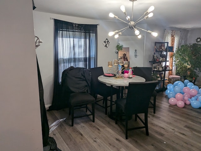 dining area with wood-type flooring and a notable chandelier