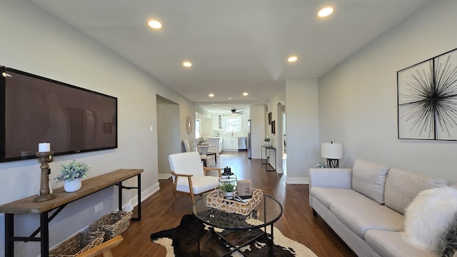 living room featuring ceiling fan and dark hardwood / wood-style flooring