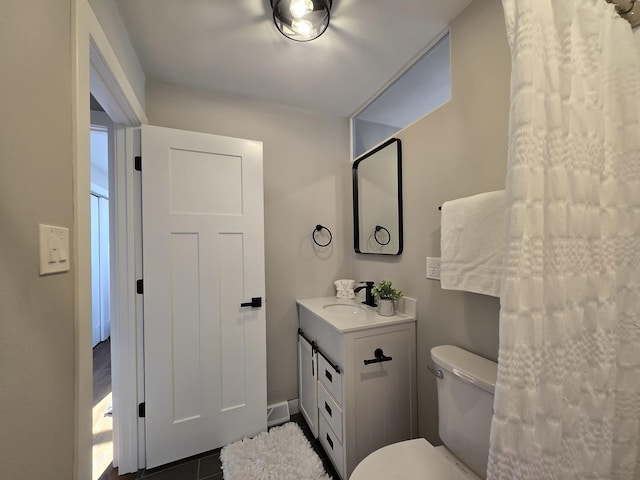 bathroom featuring toilet, vanity, and tile patterned flooring