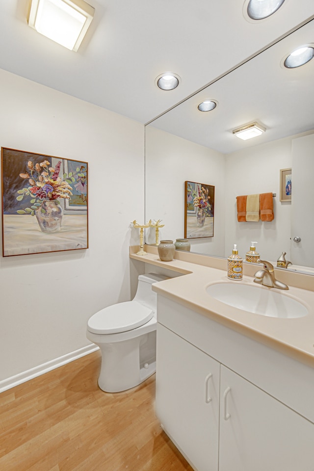 bathroom featuring toilet, vanity, and hardwood / wood-style flooring