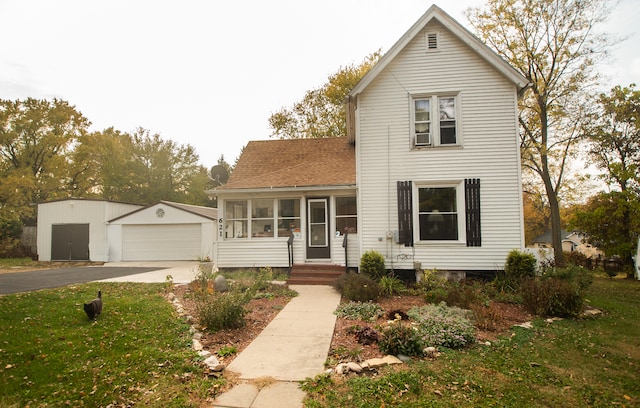 view of front of house featuring an outdoor structure, a garage, and a front lawn