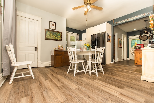 dining area with light hardwood / wood-style floors and ceiling fan