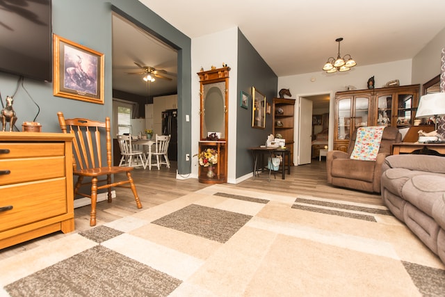 living room with wood-type flooring and ceiling fan with notable chandelier