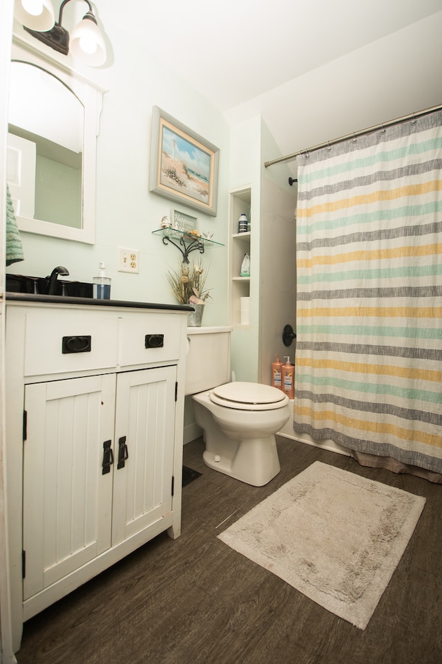 bathroom featuring vanity, toilet, hardwood / wood-style flooring, and curtained shower