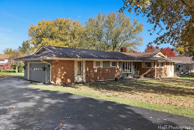 single story home with a garage and a front lawn