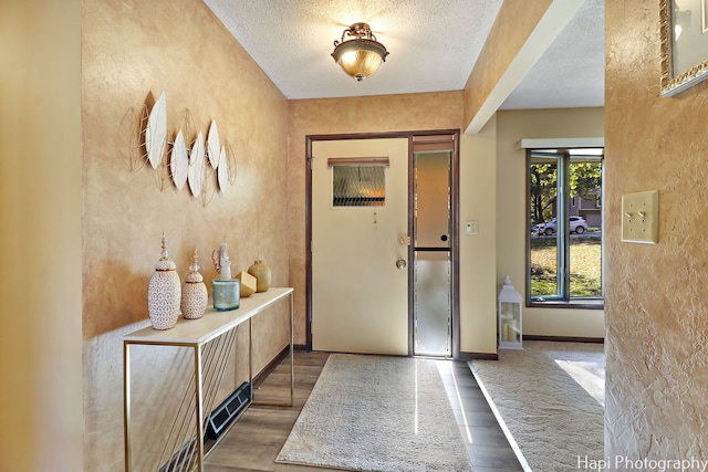 foyer entrance with a textured ceiling and hardwood / wood-style floors