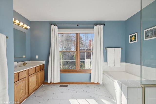 bathroom featuring vanity and a washtub