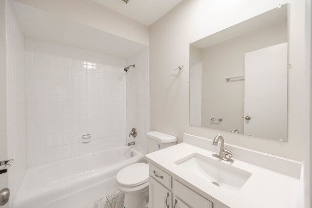 full bathroom featuring toilet, tiled shower / bath combo, and vanity