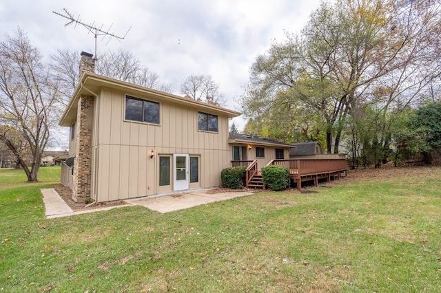 back of property featuring a wooden deck and a yard