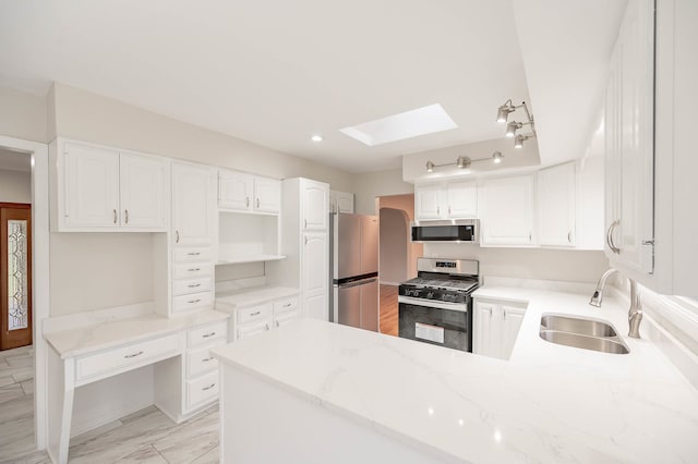 kitchen with kitchen peninsula, sink, light stone countertops, white cabinetry, and appliances with stainless steel finishes