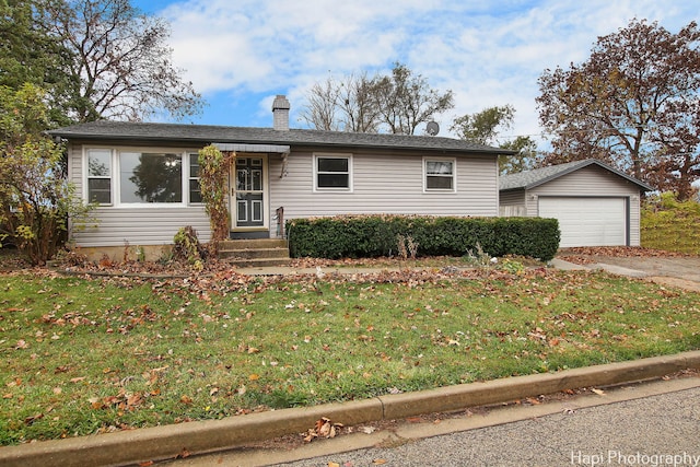 view of front of property with a front lawn, a garage, and an outdoor structure