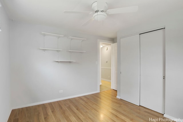 unfurnished bedroom with light wood-type flooring, ceiling fan, and a closet