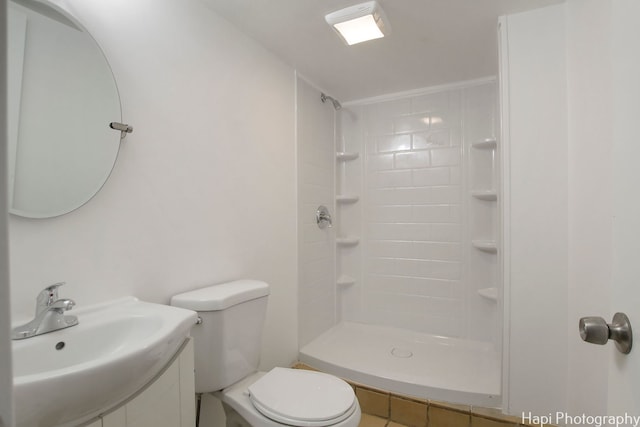 bathroom with toilet, tile patterned flooring, sink, and a tile shower