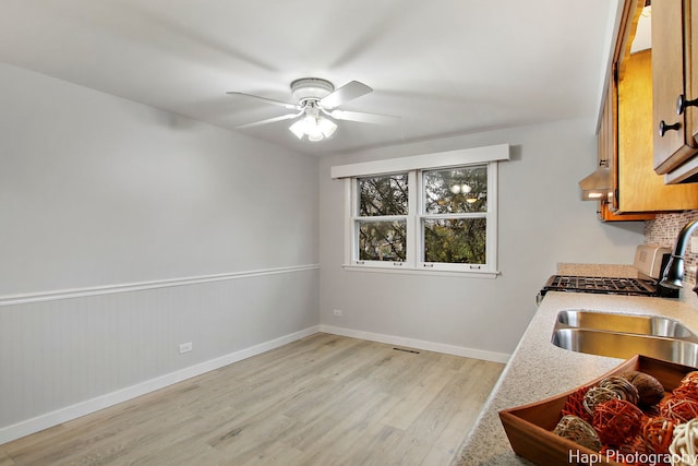 kitchen featuring light wood-type flooring, sink, and ceiling fan