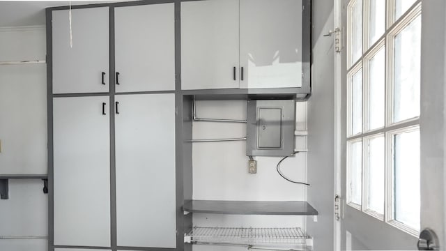 kitchen featuring electric panel and white cabinetry