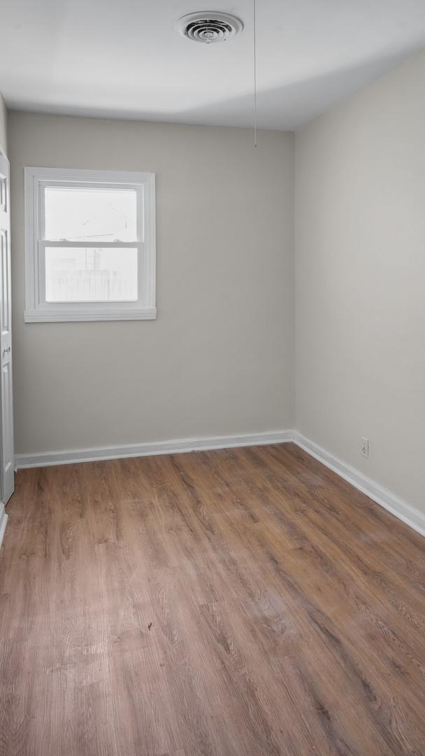 spare room with wood-type flooring