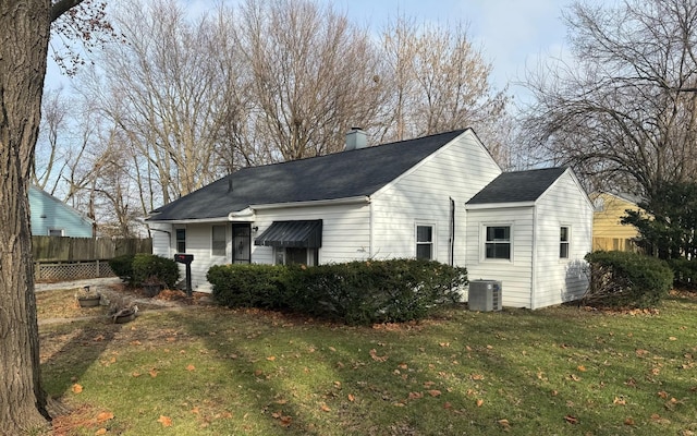 rear view of house featuring a yard and central AC