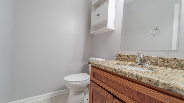 bathroom with toilet, vanity, and tile patterned floors