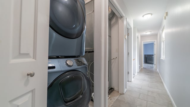 clothes washing area featuring stacked washer and dryer