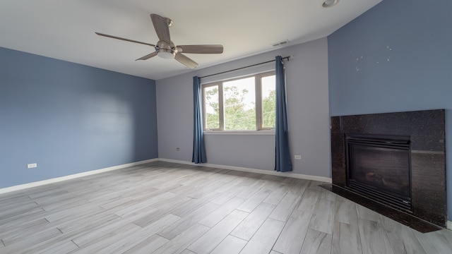 unfurnished living room featuring ceiling fan, vaulted ceiling, and light wood-type flooring