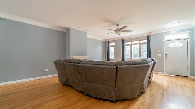 living room featuring ornamental molding, light wood-type flooring, and ceiling fan