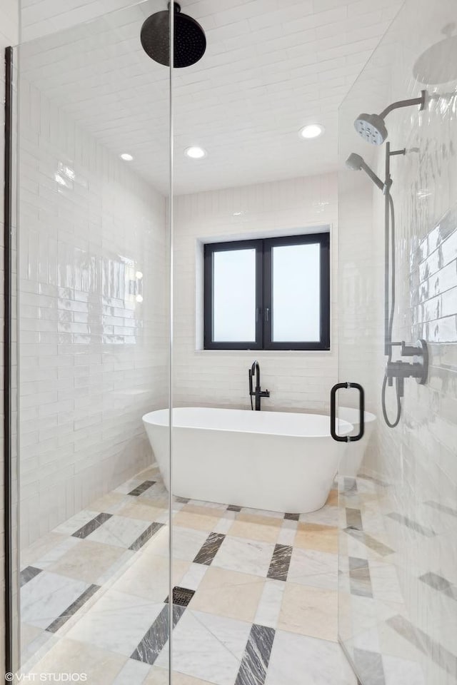 bathroom with tile walls, tile patterned floors, and independent shower and bath