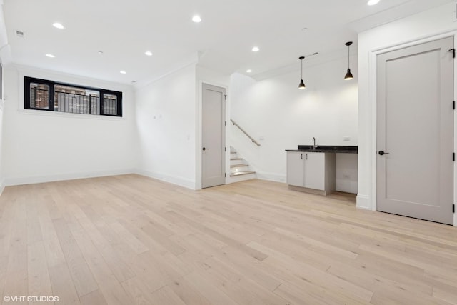 interior space with ornamental molding and light hardwood / wood-style floors